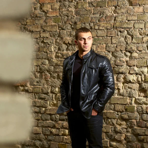 Brutal young sexual man in a leather jacket — Stock Photo, Image