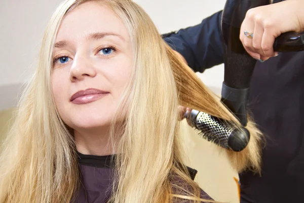 Frisörer händer torkning långa blonda hår — Stockfoto