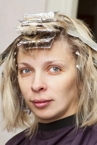 Женщина с цветной фольгой на волосах — стоковое фото
