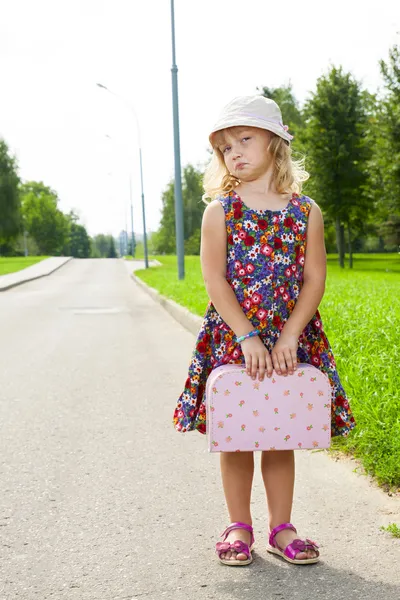 Girl with suitcase standing on road — Stock Photo, Image