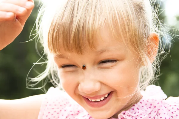 Girl with ladybird on her nose — Stock Photo, Image