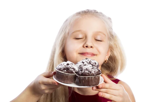 Flicka sniffa choklad muffins — Stockfoto