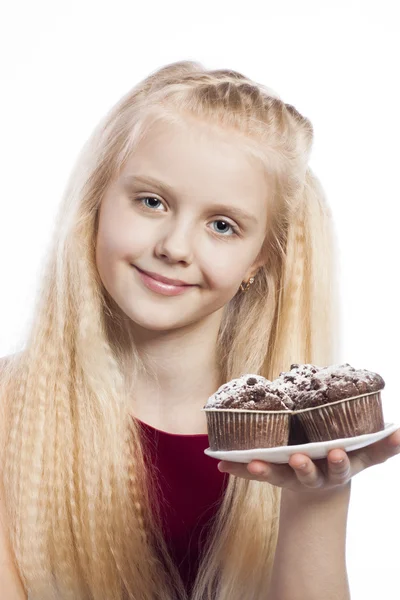 Meisje kijkend naar chocolade muffins — Stockfoto