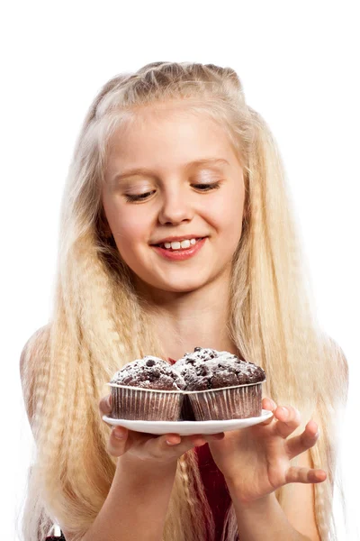 Mädchen schaut sich Schokoladenmuffins an — Stockfoto