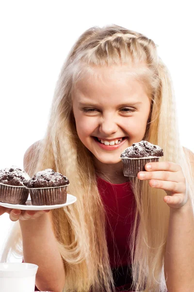 Flickan tittar på chokladmuffins — Stockfoto