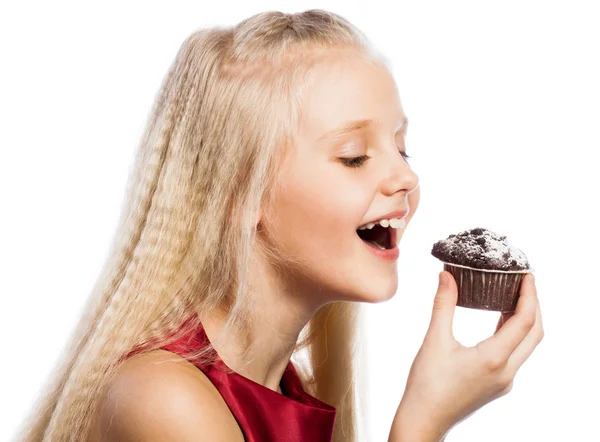 Mädchen beißt in einen Schokoladenkuchen — Stockfoto