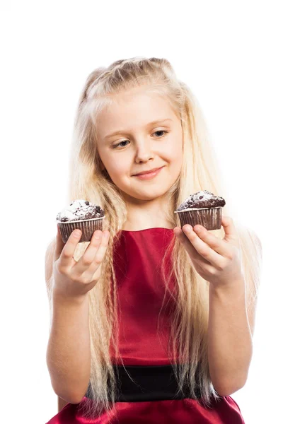 Girl making a choice between two cakes — Stock Photo, Image