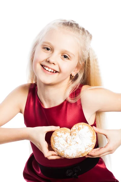 Girl holding a heart-shaped biscuit — Stock Photo, Image