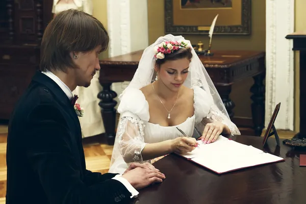 A noiva e o noivo assinam o contrato de casamento — Fotografia de Stock