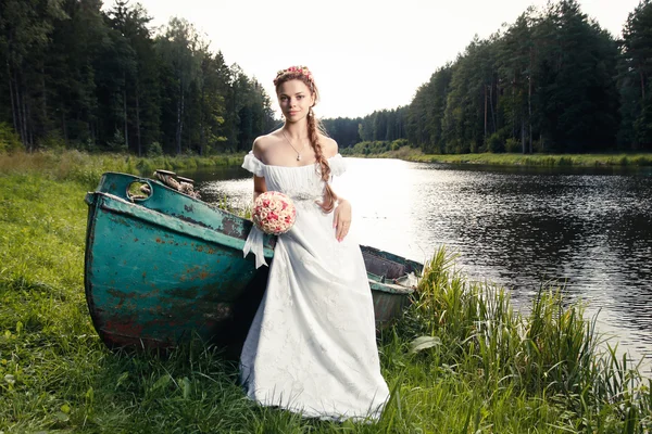 Bela jovem noiva sentada no barco — Fotografia de Stock