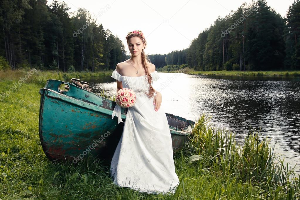 Beautiful young bride sitting on boat