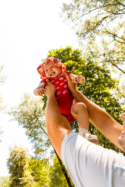 Father tossing up his daughter laughing — Stock Photo, Image