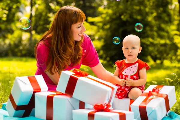 Joyful kid girl and mother with gift boxes Stock Photo