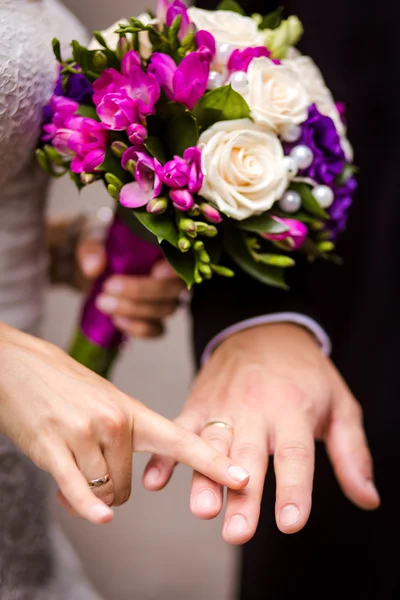 Brud- och brudgummen håller varandra i handen — Stockfoto