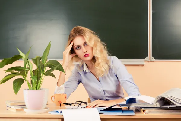 Tired teacher checking the tests. — Stock Photo, Image