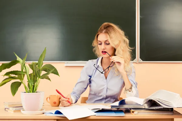 Jonge mooie leraar controleren de tests. — Stockfoto