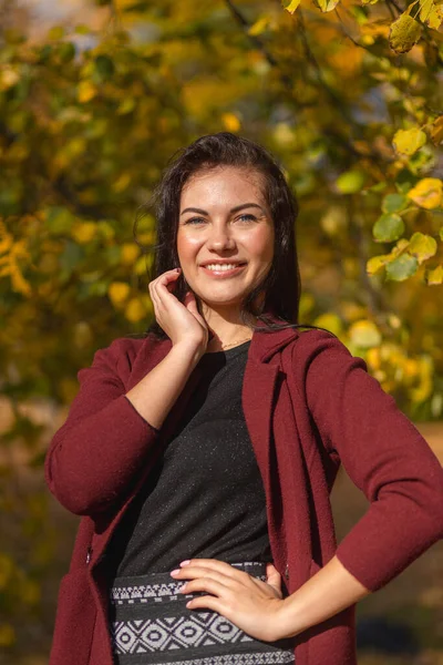 一个快乐的年轻女子在秋天的公园里享受的画像 美丽的黑发姑娘 穿着秋天的红色外套和黑色毛衣 放松的天性 高质量的照片 — 图库照片