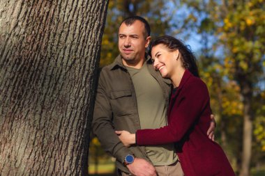 Doğada birlikte eğlenen sevimli bir çift. Erkek arkadaşı kız arkadaşına sarılıyor. Tatiller, aşk, seyahat, turizm, ilişki ve flört kavramı.