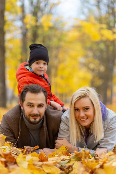 Šťastná Rodina Leží Suchém Listí Dívá Kameru Usmívá Venku Parku — Stock fotografie