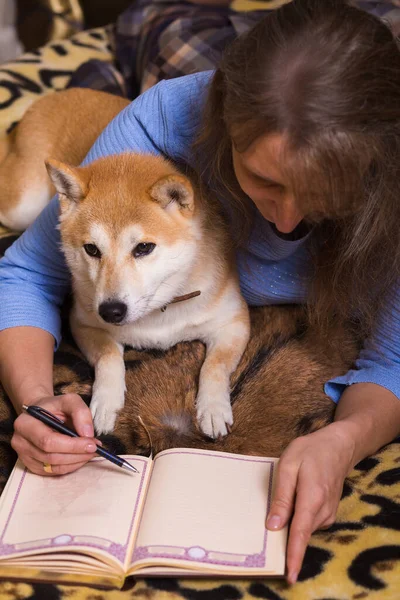 Een Vrouw Liggend Bed Schrijvend Een Dagboek Met Haar Metgezel — Stockfoto