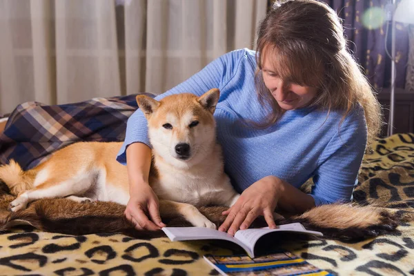 Жінка Лежить Ліжку Читає Книгу Своїм Супутником Шиба Іну Собакою — стокове фото