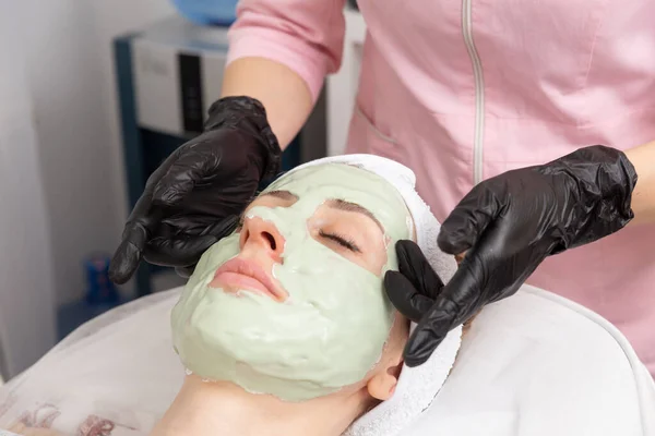 Ein Kosmetiker Gummihandschuhen Trägt Eine Creme Maske Auf Und Massiert — Stockfoto