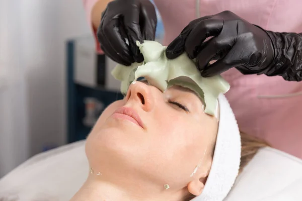 Kosmetyk Zdejmuje Glinianą Maskę Twarzy Młodej Kobiety Salonie Spa Piękna — Zdjęcie stockowe