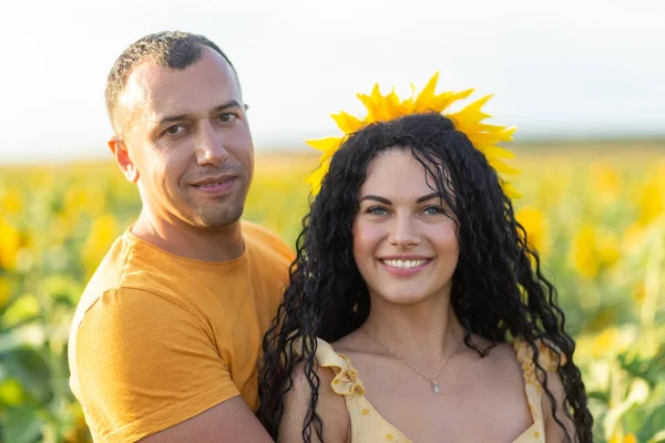 美しい若いカップルの男性と女性は 日没時にひまわりのフィールドに受け入れます 家族の夏休み ロマンチックな写真撮影の概念 — ストック写真