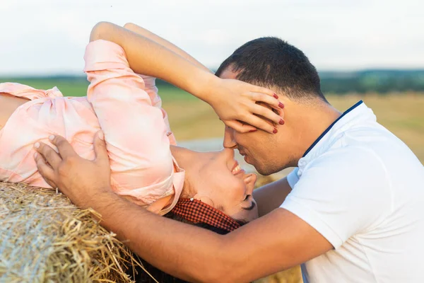 在稻草丛中的田野里爱着一对夫妻 年轻男女在日落时玩乐 拥抱和亲吻 — 图库照片