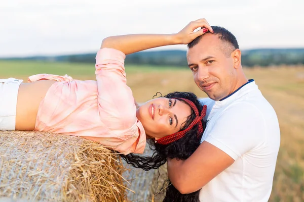 在稻草丛中的田野里爱着一对夫妻 年轻男女在日落时玩乐 拥抱和亲吻 — 图库照片