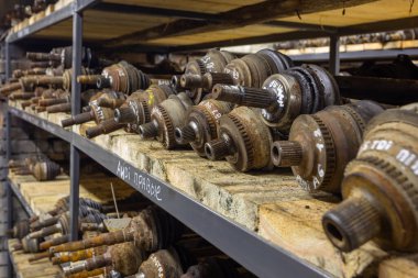 Fabrika rafında kullanılmış araba parçaları var. Çöp sahasındaki bir dükkanda satılık otomobil parçaları. Fareler, yarı dingilli araba sürücüsü. Arabaların sökülmesi.