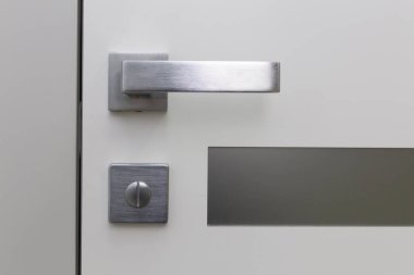 Plastik kapılı metal kapı kolu. Mimari detayların yakın plan fotoğrafı. Geometrik kavramsal arkaplan olarak iç parça.