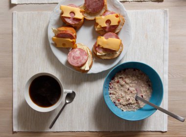 Sabah kahvaltısı, yulaf lapası, sandviç ve bir fincan kahve..