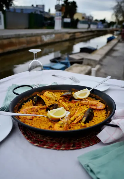 Seafood paella with glass of wine in seaside cafe,Spain — Stock Photo, Image