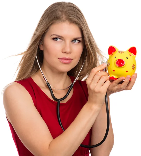 Frau mit Stethoskop und Sparschwein — Stockfoto