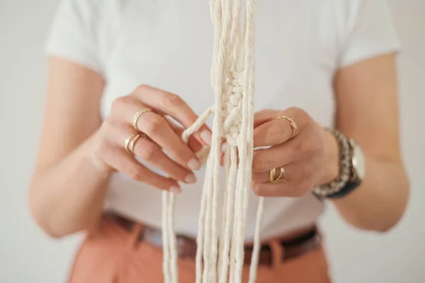 Женские руки плетут держатели цветочных горшков в макраме в стиле Бохо. — стоковое фото