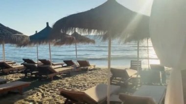 Sunbeds during golden hour sun flare sandy beach albania durres 