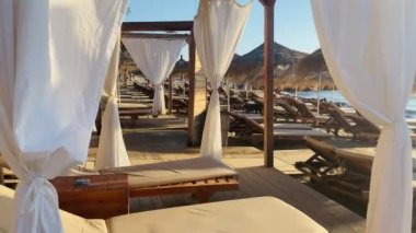 Sunbeds during golden hour sun flare sandy beach albania durres 