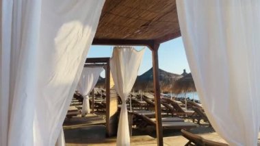 Sunbeds during golden hour sun flare sandy beach albania durres 