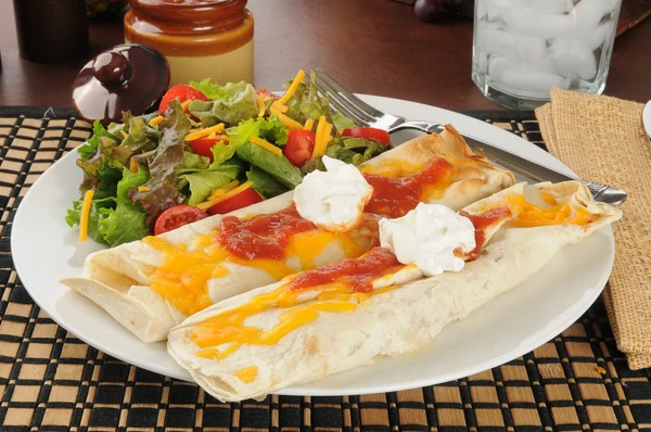 Burrito ile peynir ve salsacastañas asadas con lechuga en el plato blanco con tenedor y cuchillo aislado en blanco — Stok fotoğraf