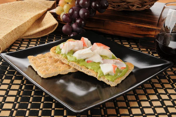 Yengeç ve guacamole kraker üzerinde — Stok fotoğraf