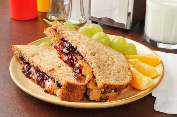 Peanut butter and jelly sandwich with fruit — Stock Photo, Image