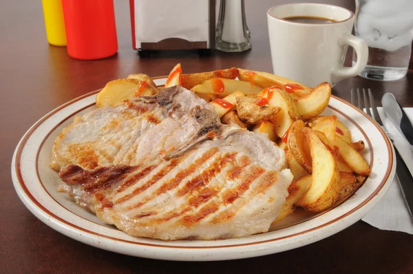 Costeletas de porco grelhadas com batatas fritas em casa — Fotografia de Stock