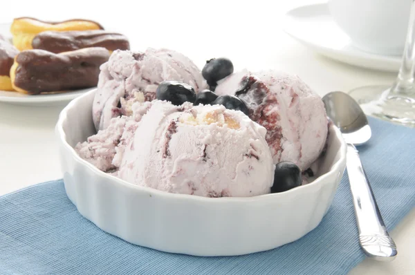 Blueberry ice cream and chocolate eclairs — Stock Photo, Image
