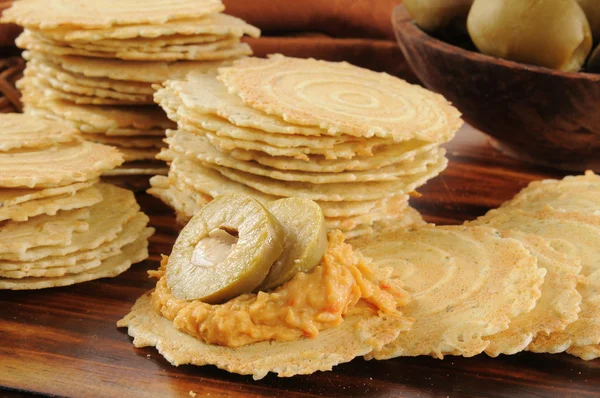 Hummus and green olives on crispbread crackers — Stock Photo, Image