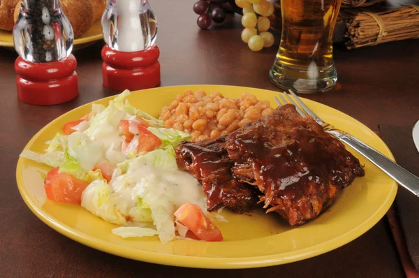 Barbecued ribs, salad and beer — Stock Photo, Image