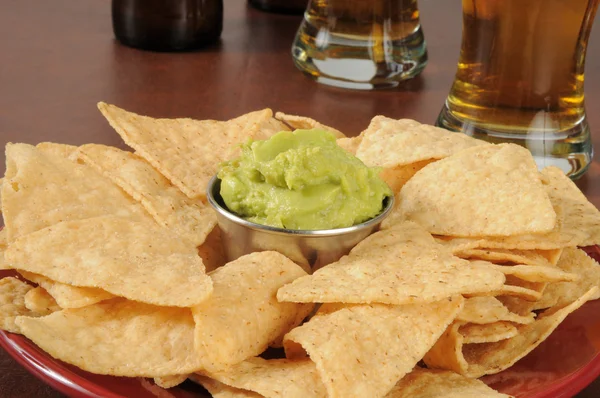 Plate of tortilla chips and guacamole on a bar counter — Stock Photo, Image