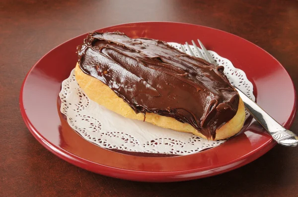 Pastel llena de crema con glaseado de chocolate — Foto de Stock