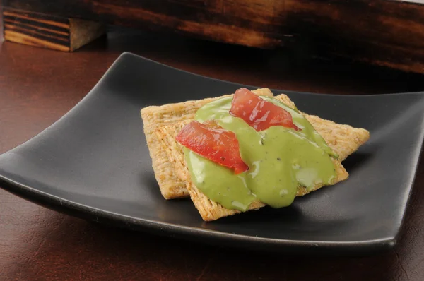 Guacamole und Tomate auf Cracker — Stockfoto