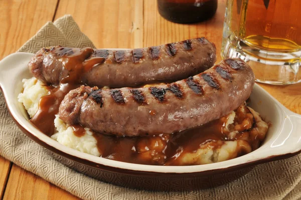 Bangers and mash on a wooden table — Stock Photo, Image